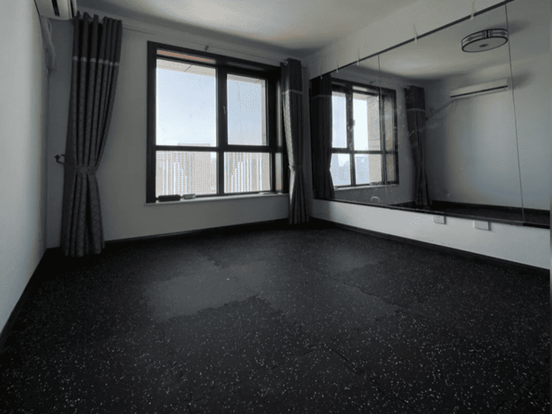 Moderna distribución de gimnasio comercial con suelo de caucho moteado en negro